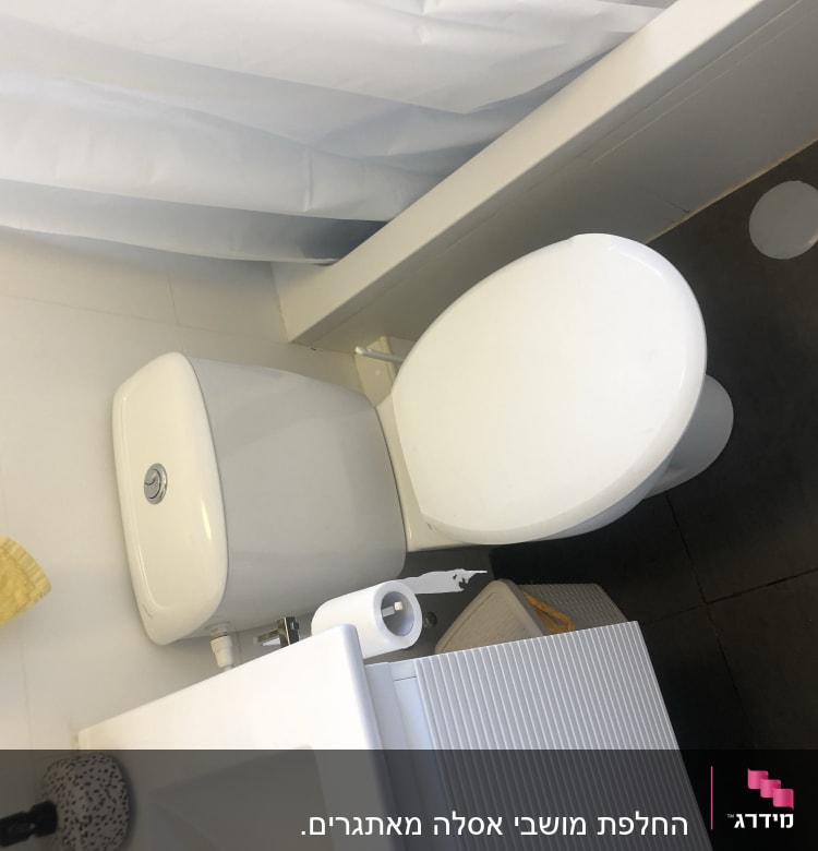 אסלה לבנה עם נייר טואלט על הרצפה